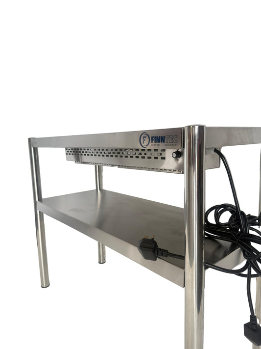 Stainless steel kitchen workstation with power cord on a white floor and wall.